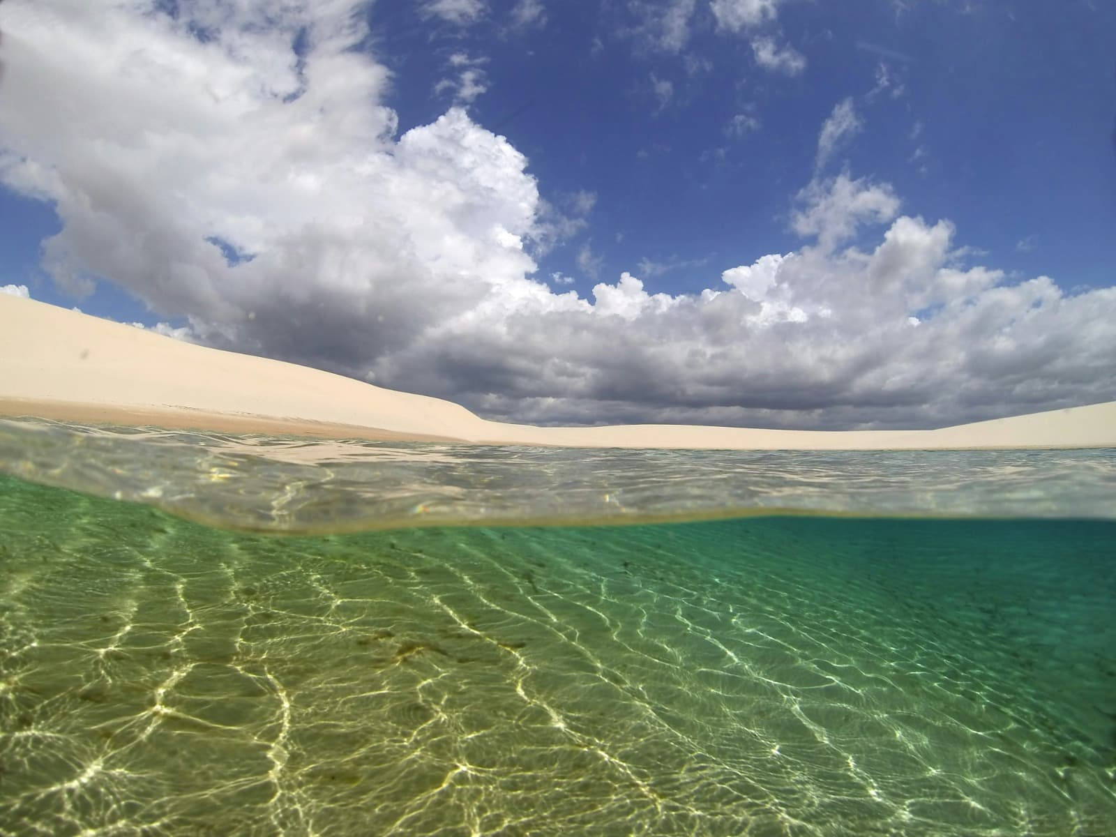Lagoa cheia entre as dunas brancas dos Lençóis Maranhenses